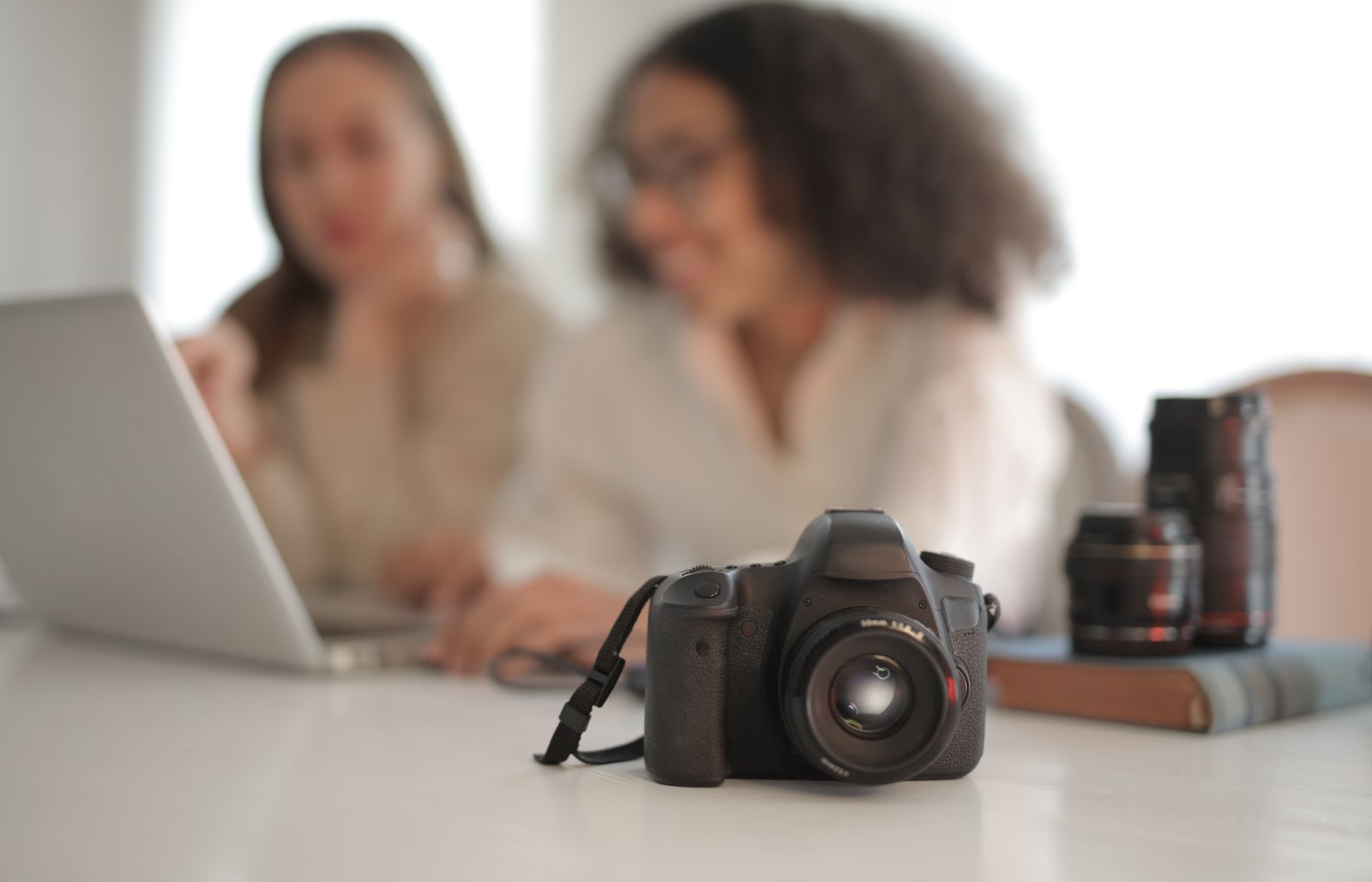 Camera with attached strap on a desk, illustrating the difference between a device and its accessory