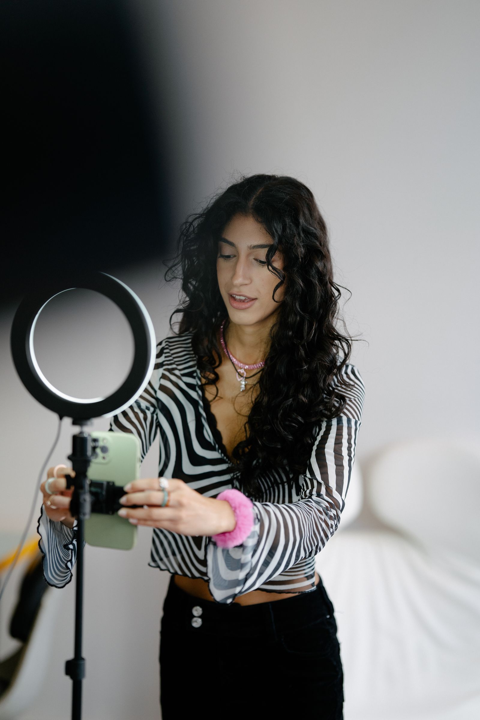 Seller adjusting a smartphone on a tripod in a small photography studio