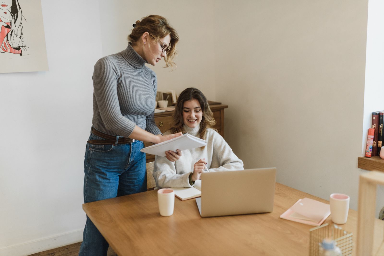 Two professionally dressed colleagues reviewing product images on a laptop
